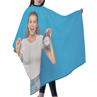 Personality  Excited Young Woman With Open Mouth Holding Alarm Clock On Blue Background, Face Expression Hair Cutting Cape
