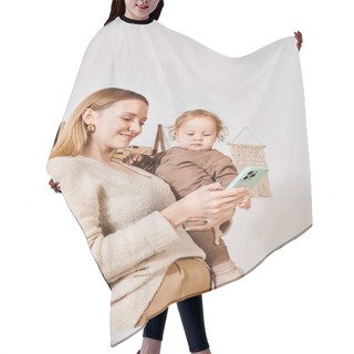 Personality  Young Mother With Toddler Son In Hands Messaging On Mobile Phone In Nursery Room, Multitasking Woman Hair Cutting Cape