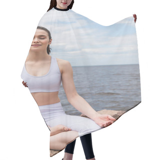 Personality  Cheerful Woman In Sportswear Sitting In Lotus Pose While Meditating Near Sea  Hair Cutting Cape