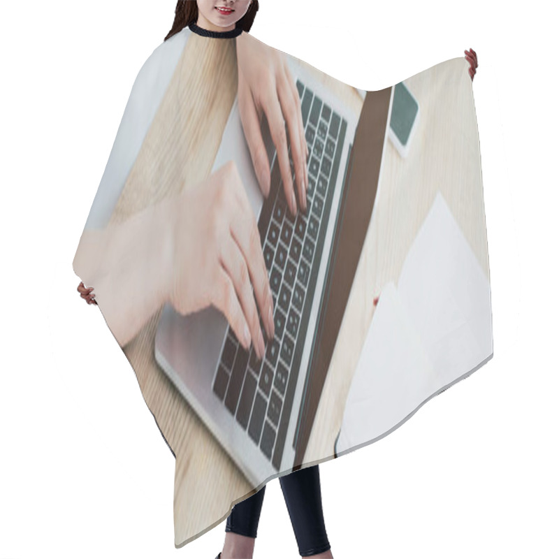 Personality  panoramic shot of businesswoman using laptop while sitting at workplace hair cutting cape