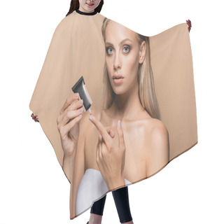Personality  Blonde Woman Applying Makeup Foundation On Finger Isolated On Beige Hair Cutting Cape