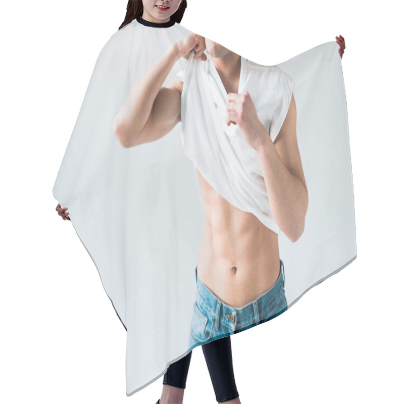 Personality  cropped view of man taking off white t-shirt and standing on white  hair cutting cape
