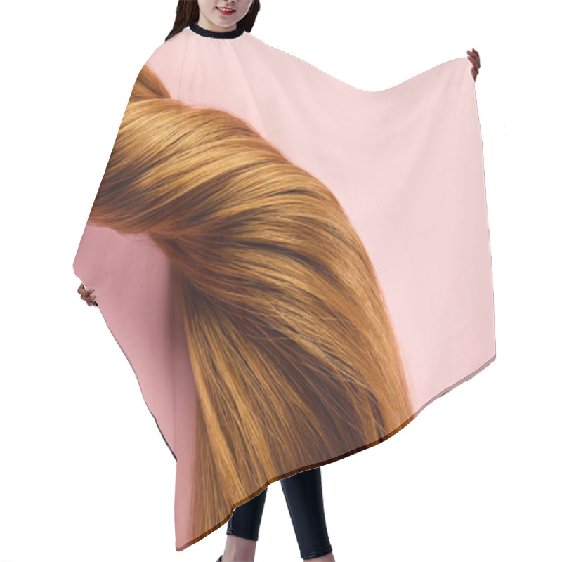 Personality  Top view of twisted brown hair on pink background hair cutting cape