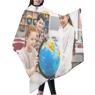 Personality  Three Cheerful Pupils Playing With Globe In Classroom During Geography Lesson Hair Cutting Cape
