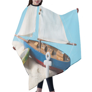 Personality  Miniature Ship Near Compass And Anchor In White Sand Isolated On Blue Hair Cutting Cape
