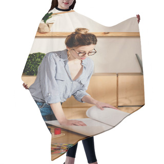 Personality  Stylish Female Artist In Eyeglasses Rolling Canvas On Table With Painting Supplies  Hair Cutting Cape