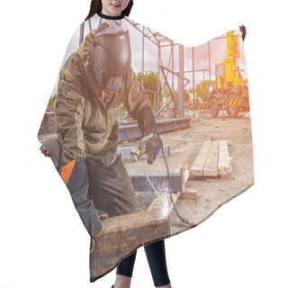Personality  A Strong Man Is A Welder In Brown Uniform, Welding Mask And Welders Leathers, A Metal Product Is Welded With A Arc Welding Machine At The Construction Site, Blue Sparks Fly To The Sides Hair Cutting Cape