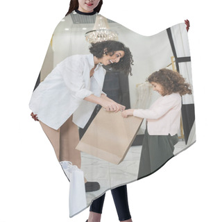 Personality  Excited Middle Eastern Woman With Brunette Hair In White Shirt And Happy Little Girl Looking Inside Of Shopping Bag Near Wedding Dresses In Bridal Salon, Mother And Daughter, Bridal Shopping  Hair Cutting Cape