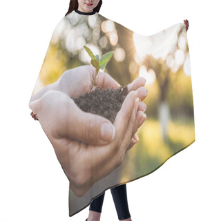 Personality  Partial View Of Woman Holding Plant With Ground In Hand Palms  Hair Cutting Cape