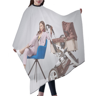 Personality  Stylish Woman Holding Baby Stroller While Sitting On Chair And Looking Away On Grey Hair Cutting Cape