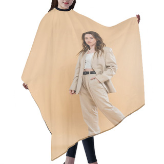 Personality  Fashion Trend Concept, Young Woman With Wavy Hair Walking In Fashionable Suit And Looking At Camera On Beige Background, Hand In Pocket, Classic Style, Professional Attire  Hair Cutting Cape