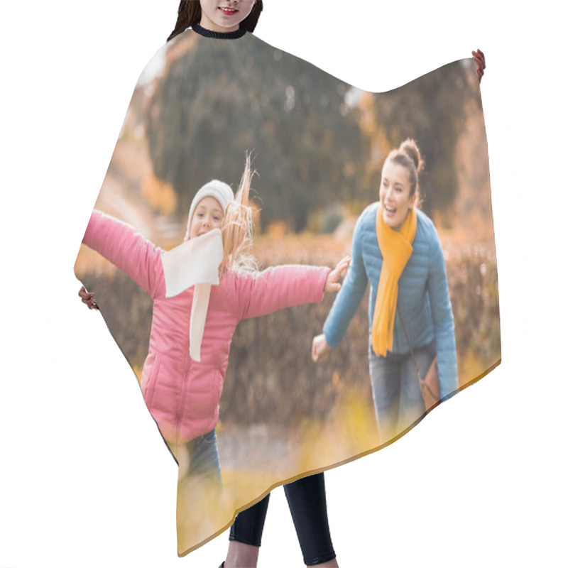 Personality  Happy mother playing with daughter in park hair cutting cape