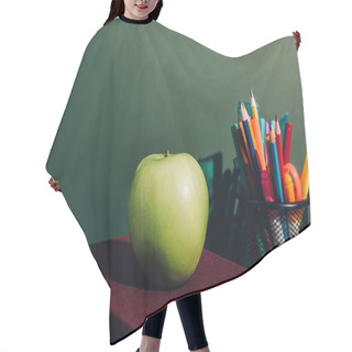 Personality  Whole Apple On Books Near Pen Holder With Color Pencils And Felt Pens On Desk Near Green Chalkboard Hair Cutting Cape