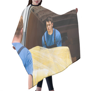 Personality  Selective Focus Of Tired Loader Carrying Couch In Stretch Wrap With Coworker Near Truck With Open Doors Outdoors Hair Cutting Cape