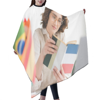 Personality  Pretty Language Teacher In Glasses Reading French Dictionary Book Near International Flags On Blurred Foreground   Hair Cutting Cape
