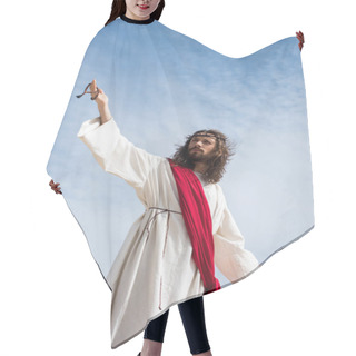 Personality  Low Angle View Of Jesus In Robe, Red Sash And Crown Of Thorns Holding Rosary And Standing With Open Arms Against Blue Sky Hair Cutting Cape