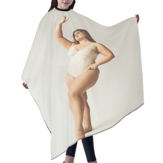 Personality  Full Length Of Brunette Curvy Woman With Plus Size Body Posing In Beige Bodysuit While Standing With Raised Hand In Studio On Grey Background, Body Positive, Figure Type, Smiling While Looking Away  Hair Cutting Cape