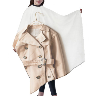 Personality  Beige Trench Coat Isolated Hanging On A Hanger In A White Wall. Close Up And Copy Space. Hair Cutting Cape