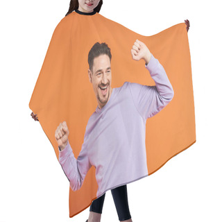Personality  Portrait Of Excited Man In Purple Sweater Dancing On Orange Background, Delighted And Fun Person Hair Cutting Cape