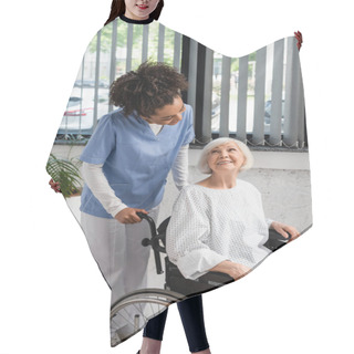 Personality  African American Nurse Looking At Elderly Patient In Gown And Wheelchair  Hair Cutting Cape