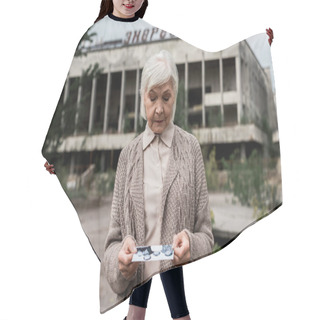 Personality  PRIPYAT, UKRAINE - AUGUST 15, 2019: Senior Woman Looking At Photo Near Building With Energetic Lettering In Chernobyl  Hair Cutting Cape