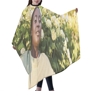 Personality  A Plus Size African American Woman Stands Confidently In Casual Attire In Front Of A Vibrant Bunch Of Flowers, Embracing The Beauty Of Nature In Summer. Hair Cutting Cape