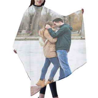Personality  Young Couple In Love, Wearing Beige And Green Casual Jackets, Standing In Front Of Frozen Lake Hugging, Kissing Each Other In Winter. Valentines Day Romantic Celebration Outside Hair Cutting Cape