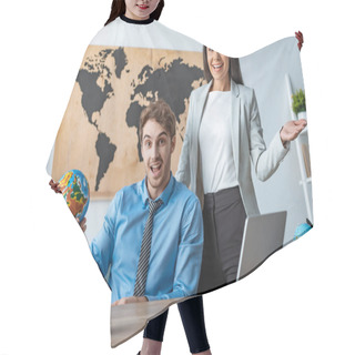 Personality  Attractive Travel Agent Showing Welcome Gesture While Standing Near Smiling Colleague Holding Globe Hair Cutting Cape