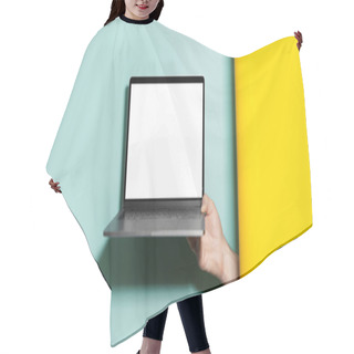 Personality  Close-up Of Male Hand Holding Laptop With Mockup Between Two Studio Backgrounds Of Yellow And Aqua Menthe Colors. Hair Cutting Cape