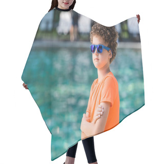 Personality  Curly Kid In Blue Sunglasses And Orange T-shirt Standing With Crossed Arms Near Pool Hair Cutting Cape