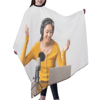 Personality  Excited Asian Announcer In Wireless Headphones Showing Wow Gesture Near Microphone And Laptop Hair Cutting Cape