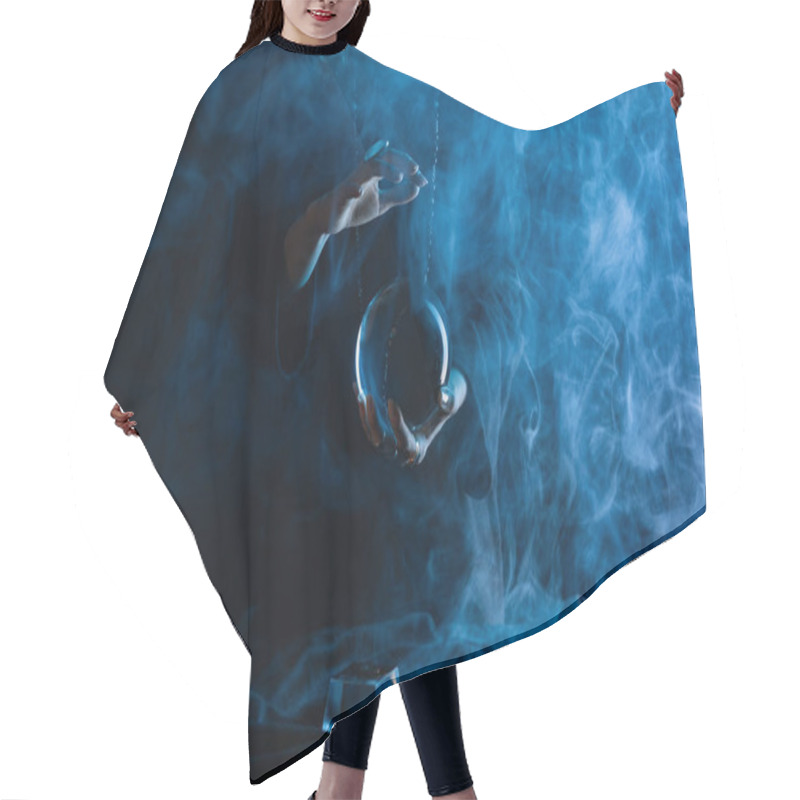 Personality  Cropped view of witch with crystal ball on dark blue background hair cutting cape