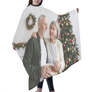Personality  Smiling Middle Aged Couple Holding Wicker Basket With Baubles Near Decorated Pine Tree Hair Cutting Cape