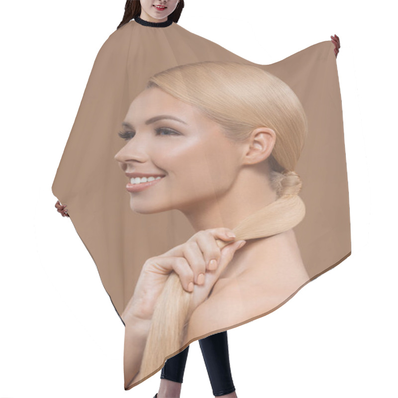 Personality  side view of smiling beautiful blonde hair girl isolated on beige hair cutting cape