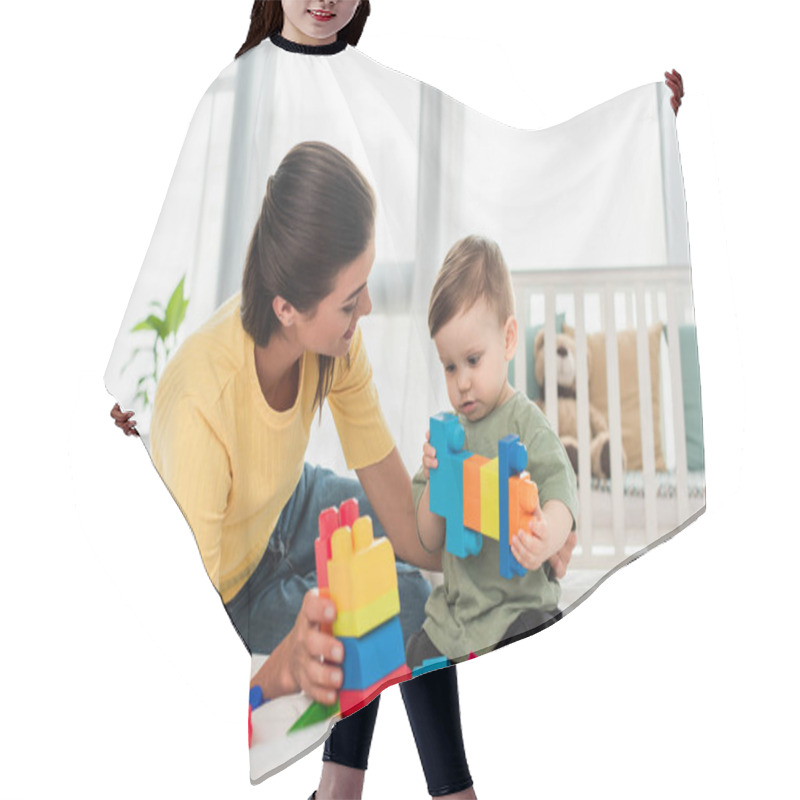 Personality  Young Woman Looking At Child Playing Building Blocks On Bed  Hair Cutting Cape