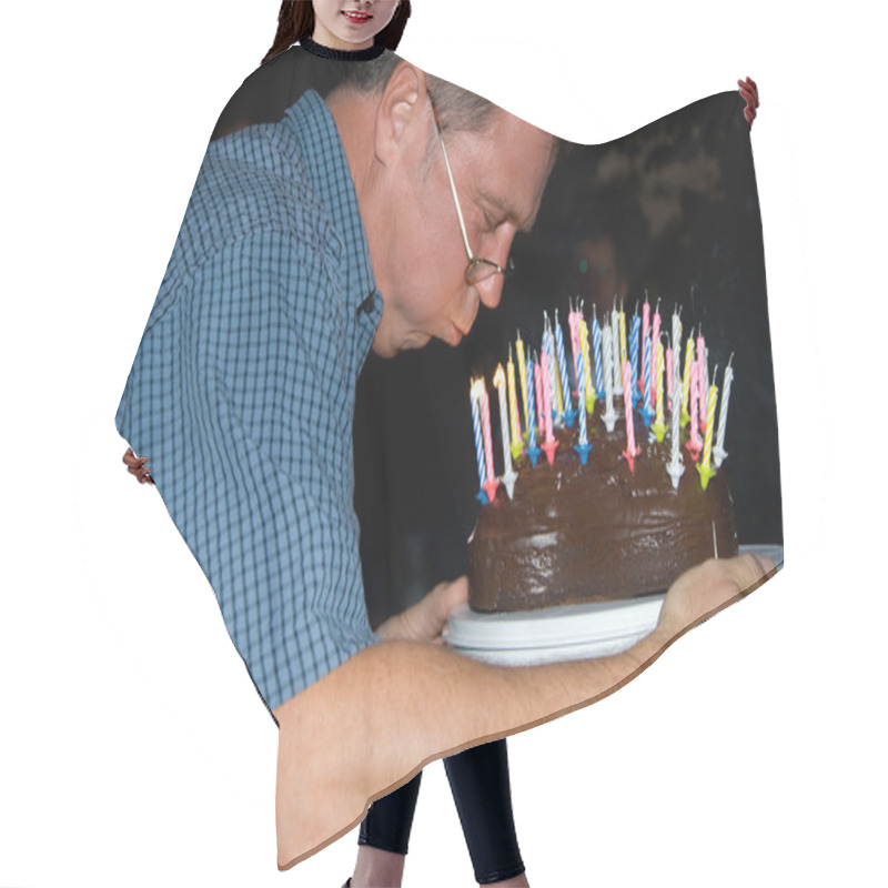 Personality  Man blows out his birthday candles at the birthday hair cutting cape