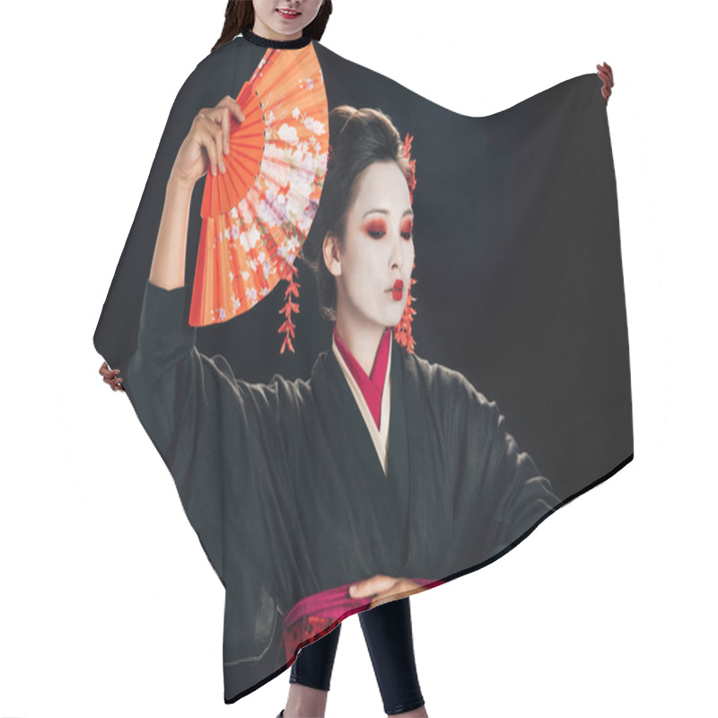 Personality  beautiful geisha in black kimono with red flowers in hair holding traditional orange hand fan isolated on black hair cutting cape