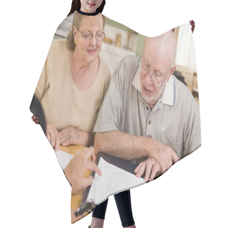 Personality  Senior Adult Couple Going Over Papers in Their Home with Agent hair cutting cape