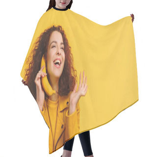 Personality  Curly Woman Imitating Phone Conversation With Banana And Smiling Isolated On Yellow Hair Cutting Cape