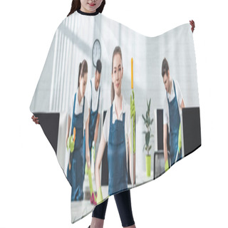 Personality  Panoramic Shot Of Smiling Cleaner Standing With Hand On Hip Near Multicultural Colleagues Hair Cutting Cape