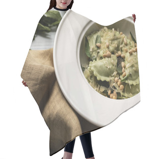 Personality  Close Up View Of Green Ravioli Served In White Plate With Sage, Pine Nuts And Grated Cheese Near Sackcloth Hair Cutting Cape