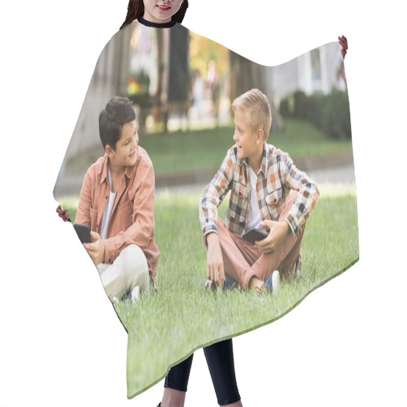 Personality  Two Smiling Brothers Talking While Sitting On Lawn With Smartphones Hair Cutting Cape
