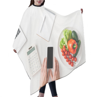 Personality  Top View Of Woman Holding Smartphone Near Calculator, Notebook And Vegetables On White Background Hair Cutting Cape