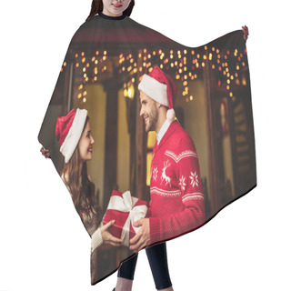 Personality  Happy Young Couple In Warm Sweaters And Santa Hats Holding Gift Box And Looking At Each Other Hair Cutting Cape