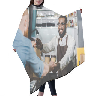 Personality  Smiling Young African American Barista Giving Disposable Coffee Cups And Paper Bag To Client In Cafe Hair Cutting Cape