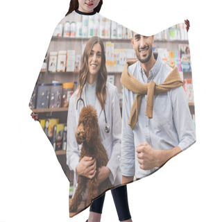 Personality  Smiling Muslim Man Looking At Camera Near Veterinarian And Poodle In Pet Shop Hair Cutting Cape