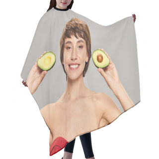 Personality  A Young Woman Gracefully Holds Two Halves Of An Avocado. Hair Cutting Cape