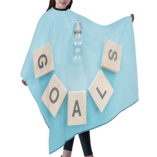 Personality  Top View Of Light Bulb Over 'goals' Word Made Of Wooden Blocks On Blue Background, Goal Setting Concept Hair Cutting Cape