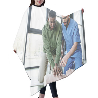 Personality  Medical Instructor In Uniform And Eyeglasses Pointing At CPR Manikin While African American Man Doing Chest Compressions, Effective Life-saving Skills And Emergency Preparedness Concept Hair Cutting Cape