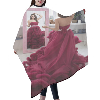 Personality  Attractive Young Woman In A Burgundy Ball Dress Looks In The Mirror. Hair Cutting Cape